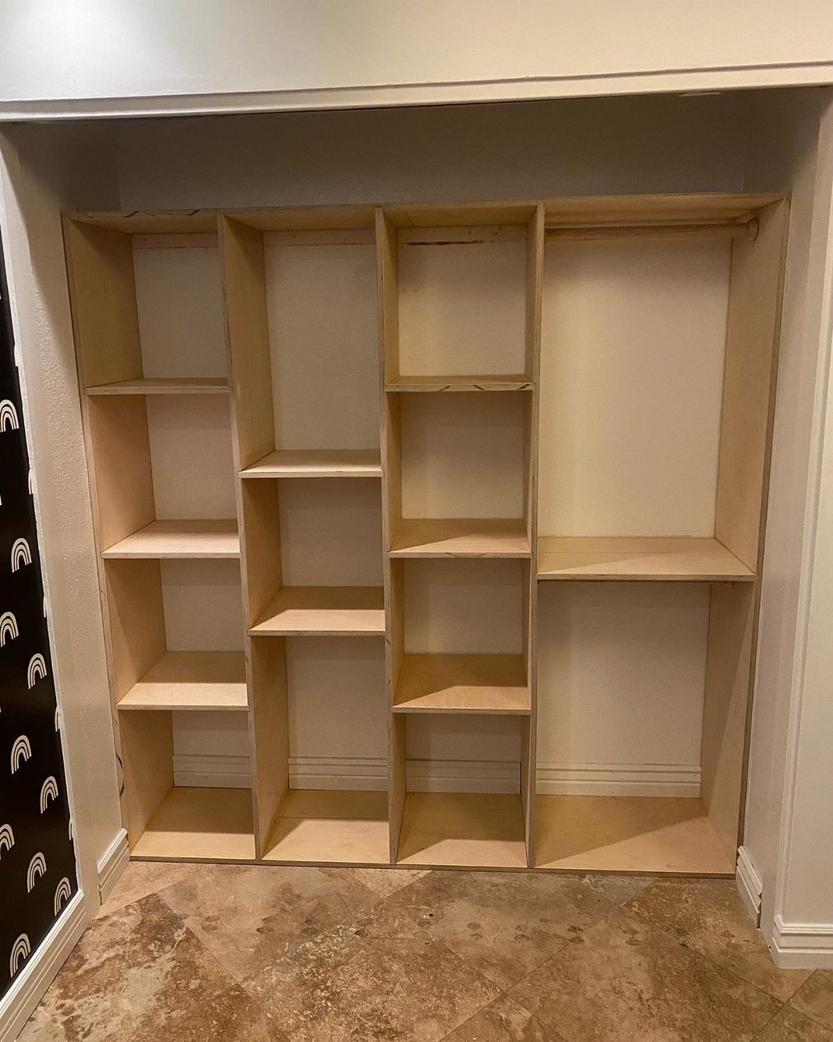 DIY Closet Organization: 16 Ideas for Every Layout 1 A newly constructed wooden closet organizer with multiple shelves and hanging compartments built into a wall alcove.