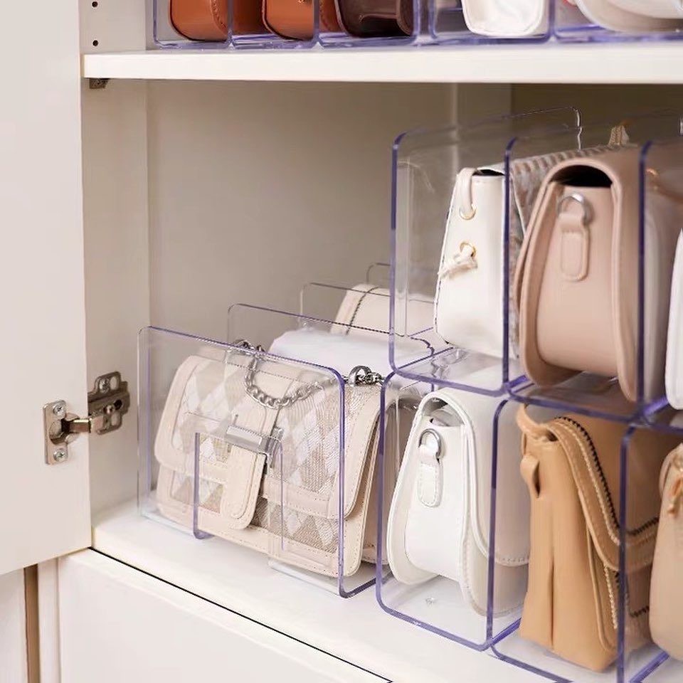 Handbag Storage and Display: 8 Ideas for Every Space 7 Small handbags organized in clear acrylic dividers on a white closet shelf.