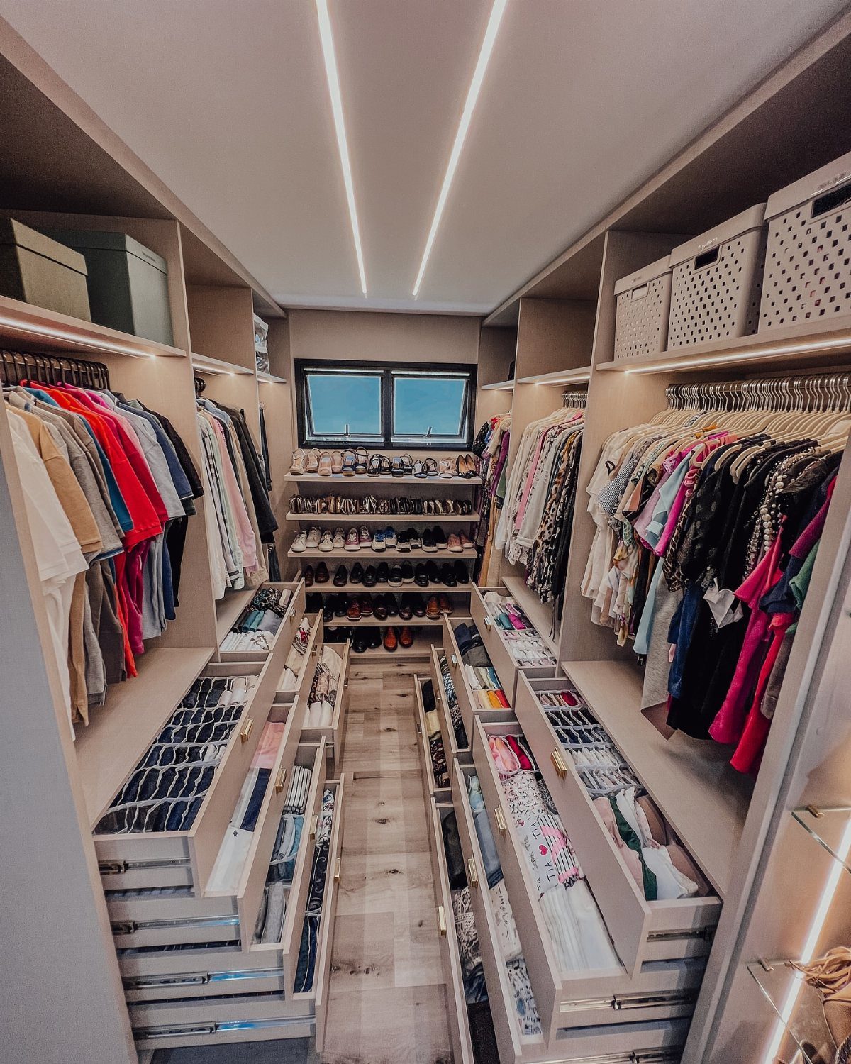 DIY Closet Organization: 16 Ideas for Every Layout 10 A walk-in closet with organized clothing, open drawers, and shoe racks lining the walls.