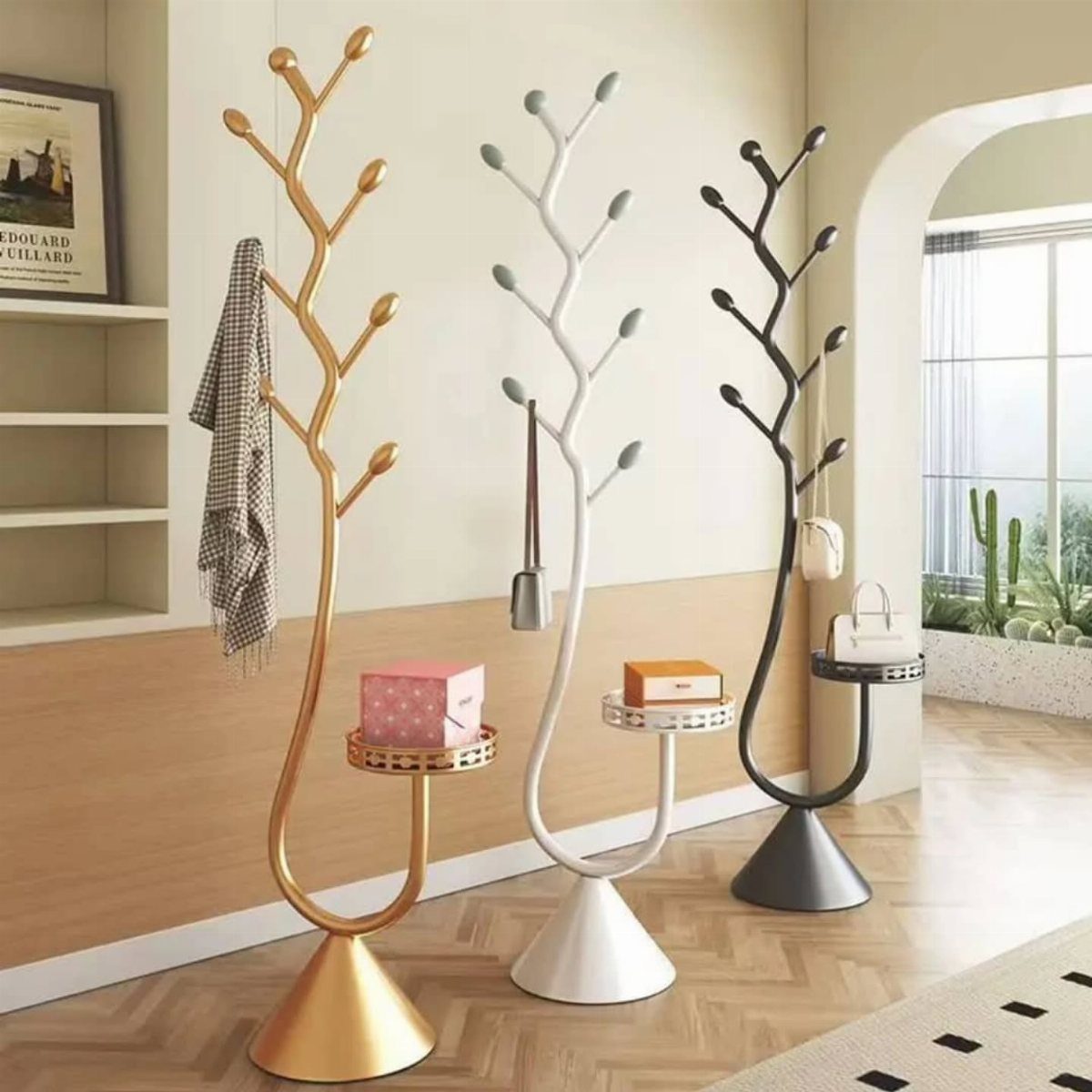 Handbag Storage and Display: 8 Ideas for Every Space 5 Three branch-style coat racks in gold, white, and black holding a scarf, a small box, and a handbag.
