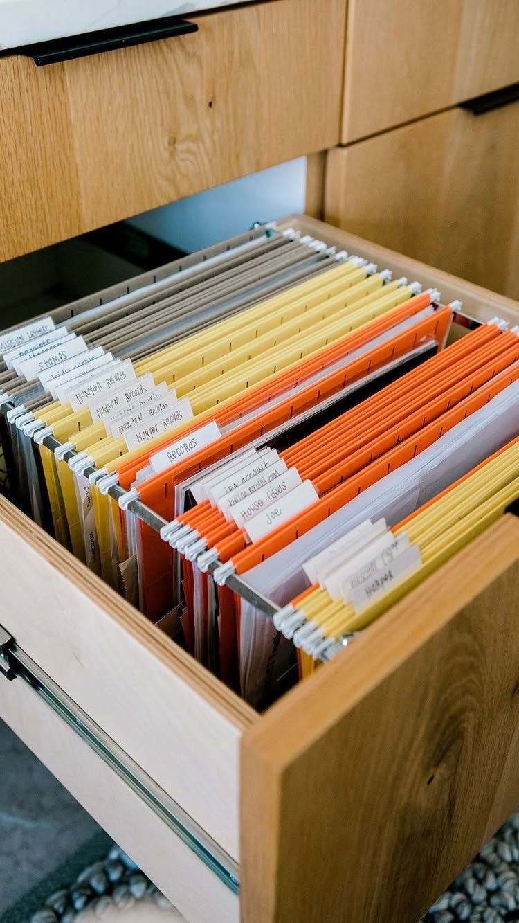 12 Office Storage Room Organization Ideas for Every Layout 7 Organized hanging file folders in various colors inside an open wooden desk drawer.