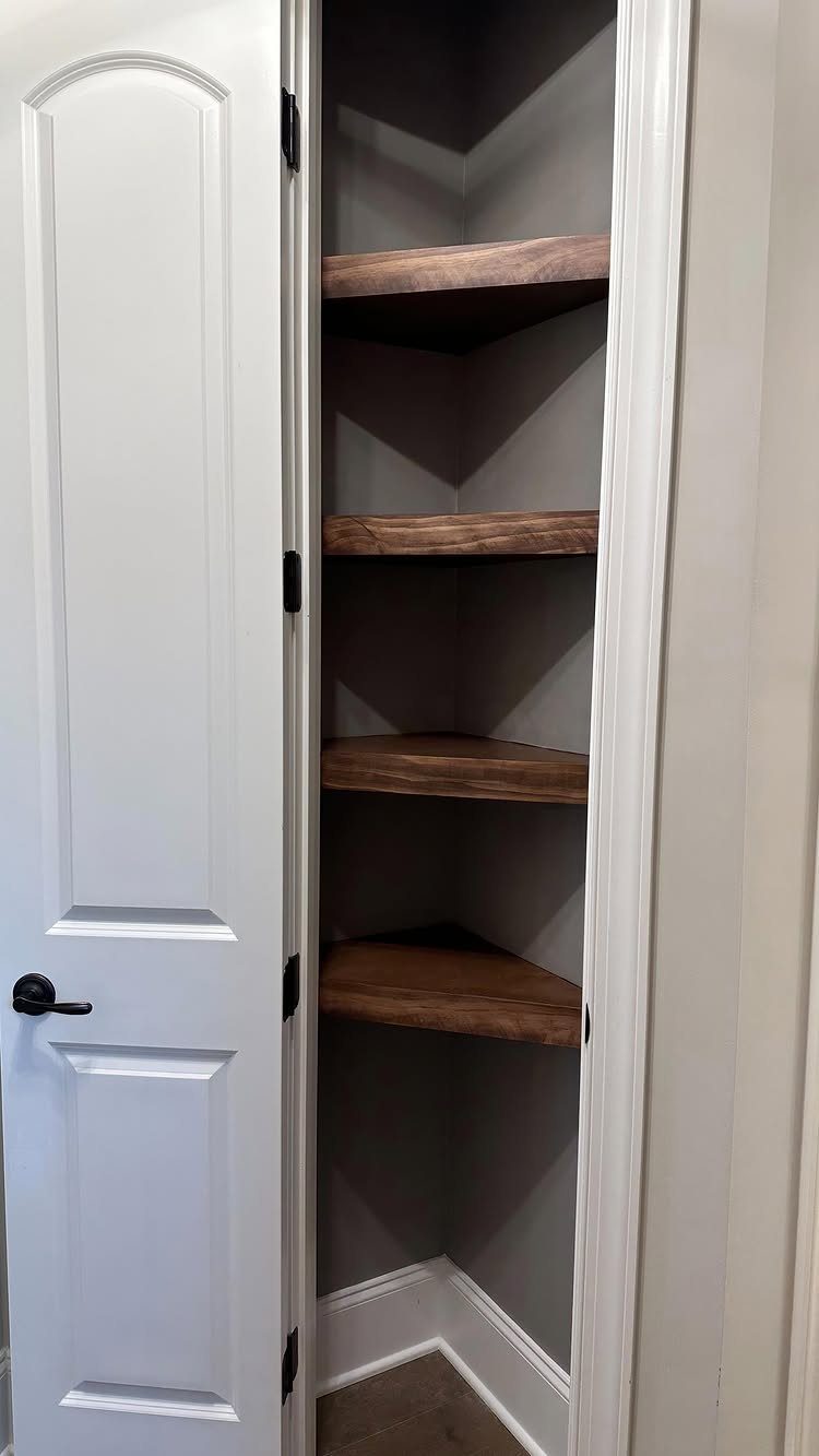 21 Closet Design Plans for Every Layout and Budget 7 Four rustic wooden corner shelves installed inside an open white closet with grey walls.