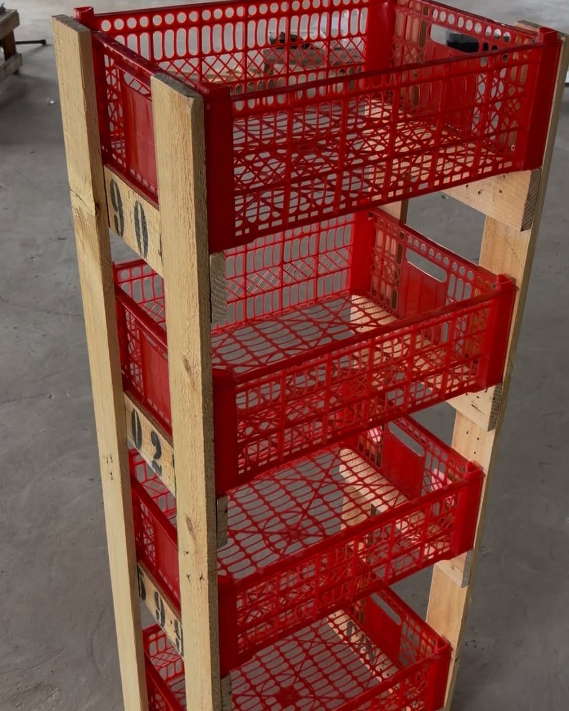 11 Tool Shed Storage Ideas for Every Wall and Corner 11 Red plastic crates stacked inside a tall wooden shelving unit on a concrete floor.