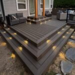 Wooden deck steps with small warm LED accent lights embedded into the risers at dusk.