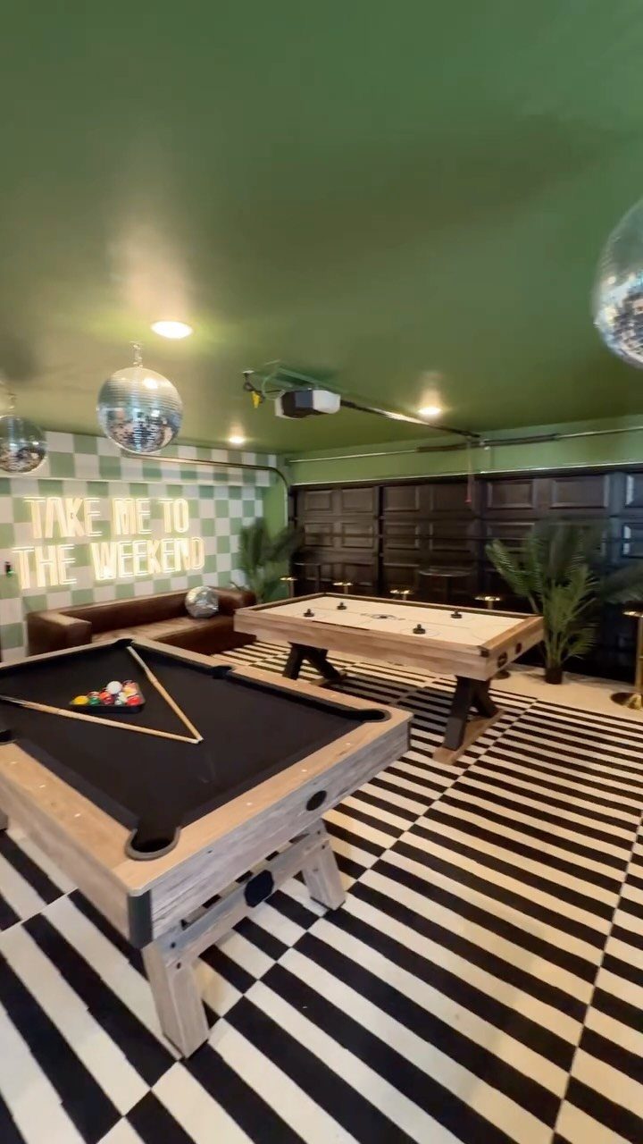 A game room with pool and foosball tables on a checkered floor.