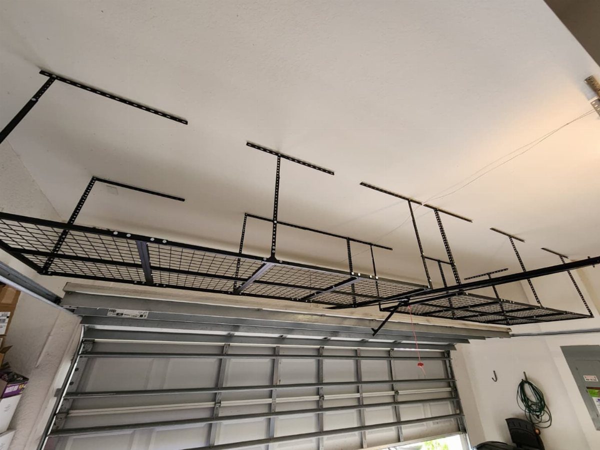 Garage Storage Modern: 12 Ideas That Free Up Floor Space 5 Black metal wire mesh storage rack mounted to a white garage ceiling above a garage door.