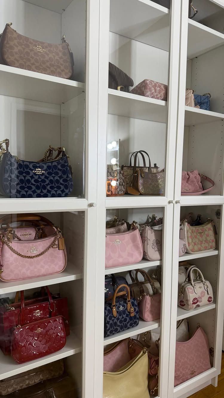 Handbag Storage and Display: 8 Ideas for Every Space 8 Various colorful designer handbags displayed neatly on white glass-fronted shelving units.