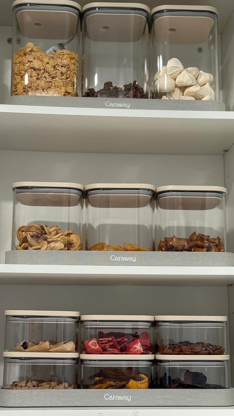 Non Toxic Kitchen Essentials: 10 Pieces That Actually Work 2 Glass food storage containers with wooden lids filled with dried snacks on white pantry shelves.