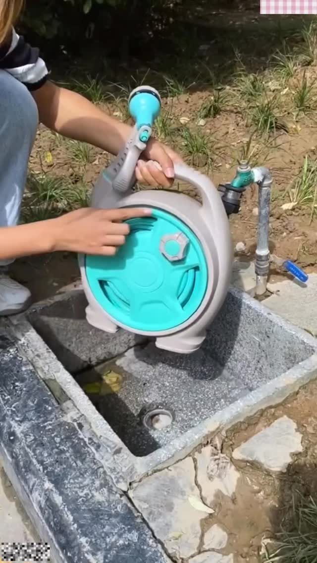 11 Garden Tool Organization Ideas for a Neater Shed or Garage 6 Hands holding a teal and grey hose reel over a concrete outdoor water basin.