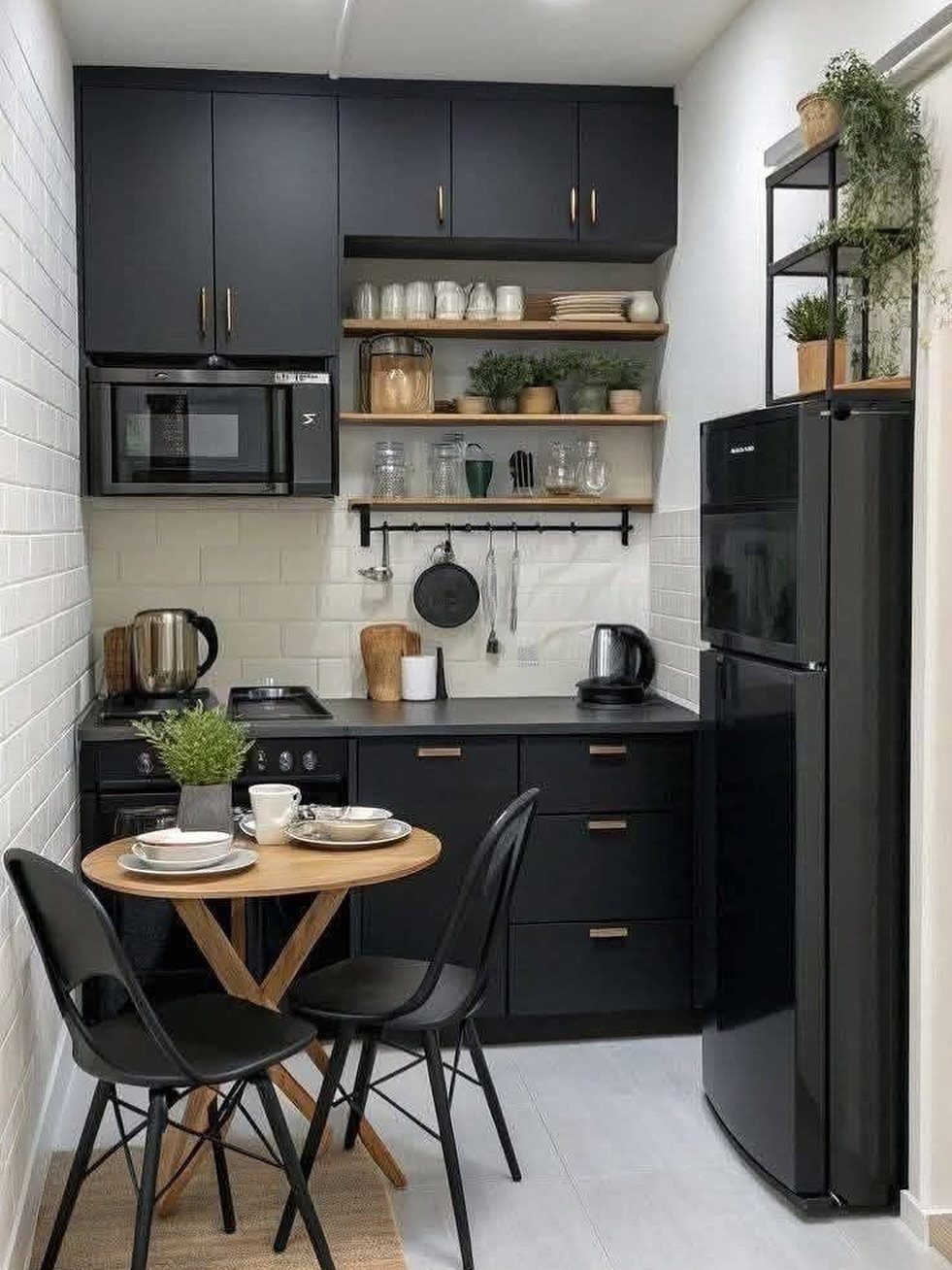 Studio Apartment Organization: 9 Ideas That Save Space 3 A compact modern kitchen featuring black cabinets, wooden shelves, and a small dining set.