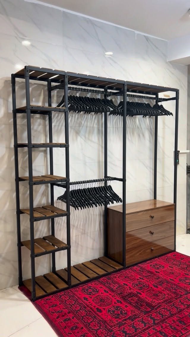 21 Closet Design Plans for Every Layout and Budget 17 Industrial style open closet system with black metal framing, wooden shelving, and a wooden dresser.