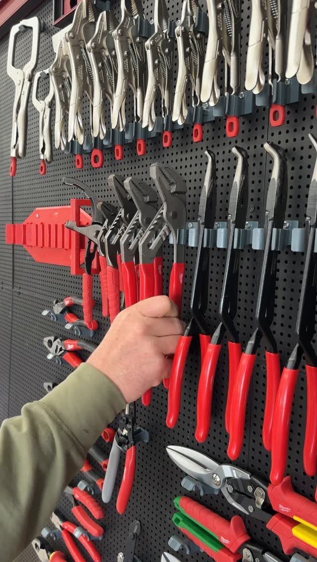 Garage Storage Modern: 12 Ideas That Free Up Floor Space 9 A hand reaches for red-handled pliers hanging on a black pegboard tool organizer.