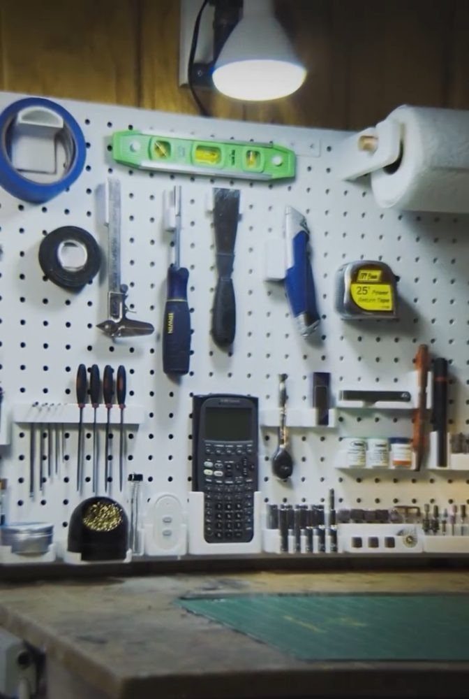 11 Tool Shed Storage Ideas for Every Wall and Corner 1 Various hand tools and supplies organized on a white pegboard in a workshop setting.