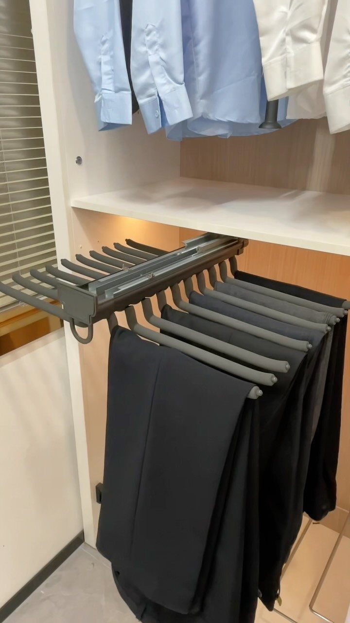 DIY Closet Organization: 16 Ideas for Every Layout 12 Black trousers hanging on a grey sliding rack beneath a white closet shelf.