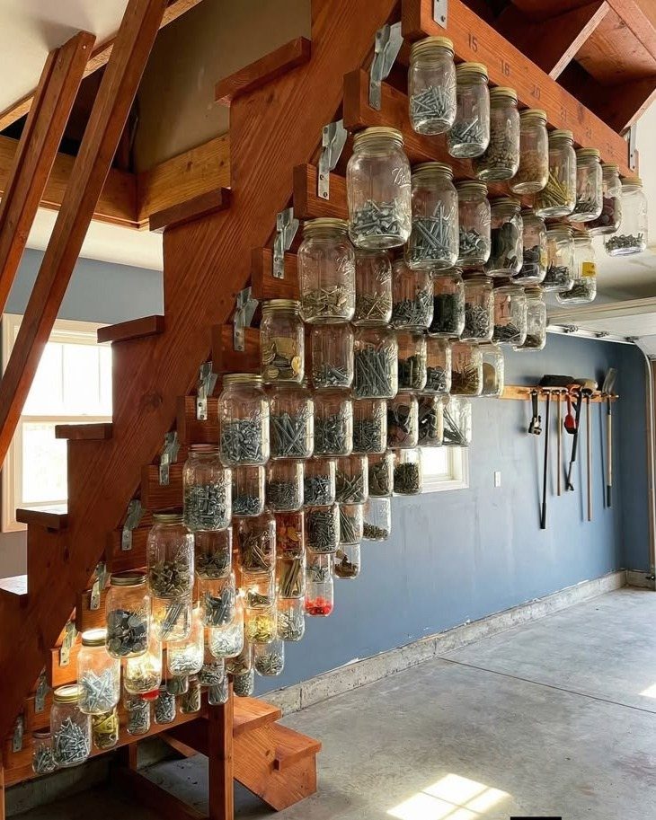 11 Garden Tool Organization Ideas for a Neater Shed or Garage 10 Glass mason jars filled with garden supplies mounted on the side of wooden stairs.
