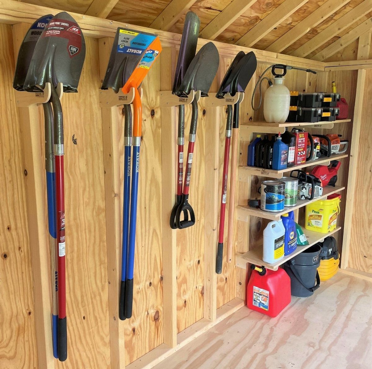 11 Tool Shed Storage Ideas for Every Wall and Corner 3 Garden shovels and spades hanging from wooden wall hooks inside a tool shed.